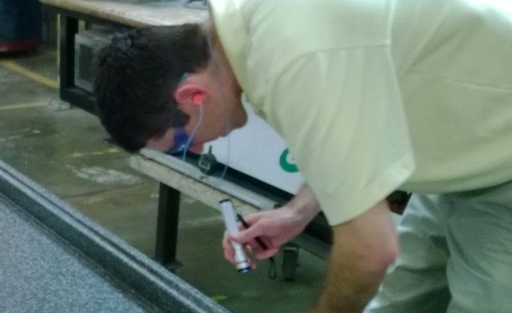 A worker finishing a long part on a production line